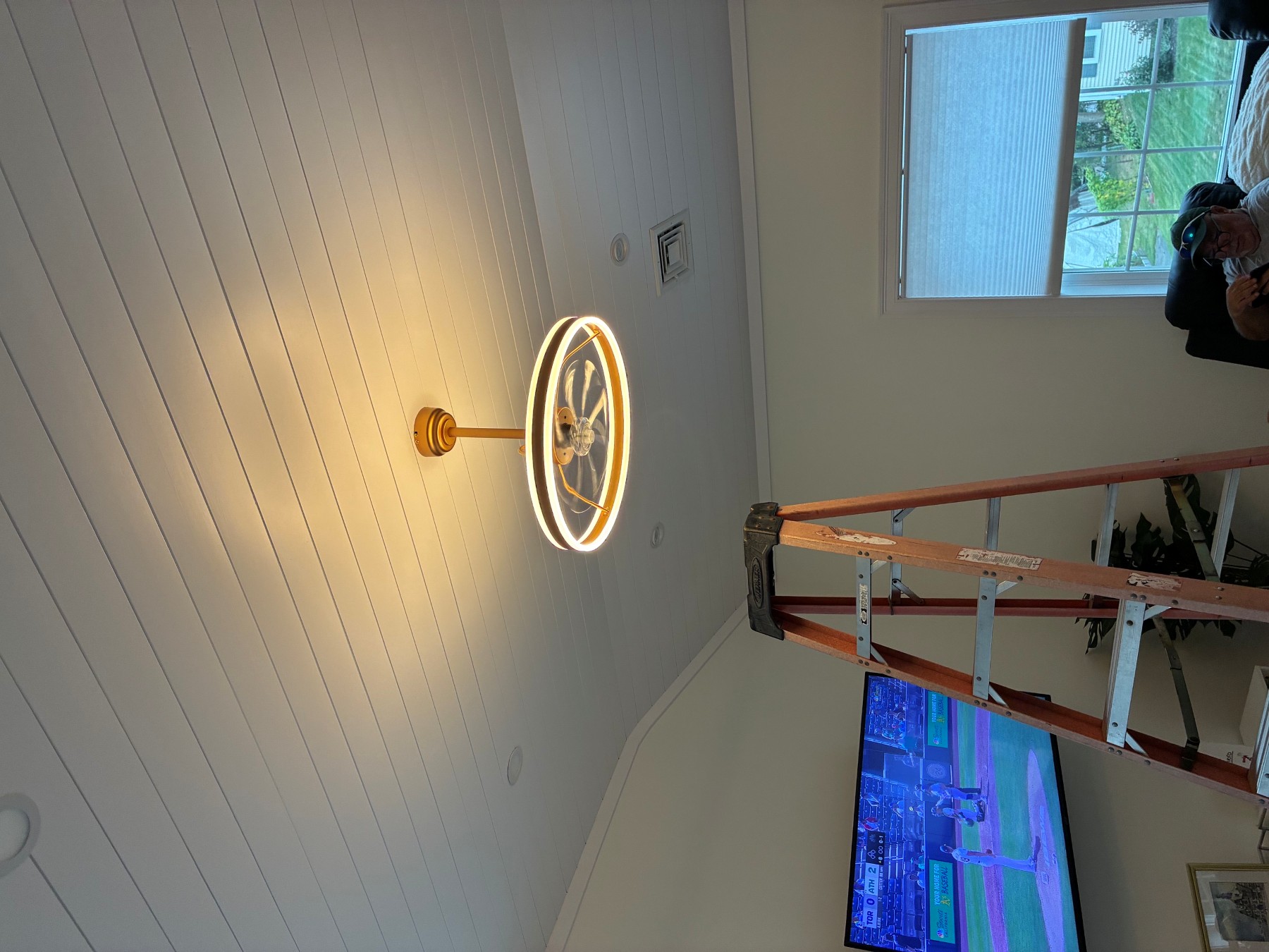 Boston Light & Power electrician installing an LED ring ceiling fan in a living room in Weymouth, MA.