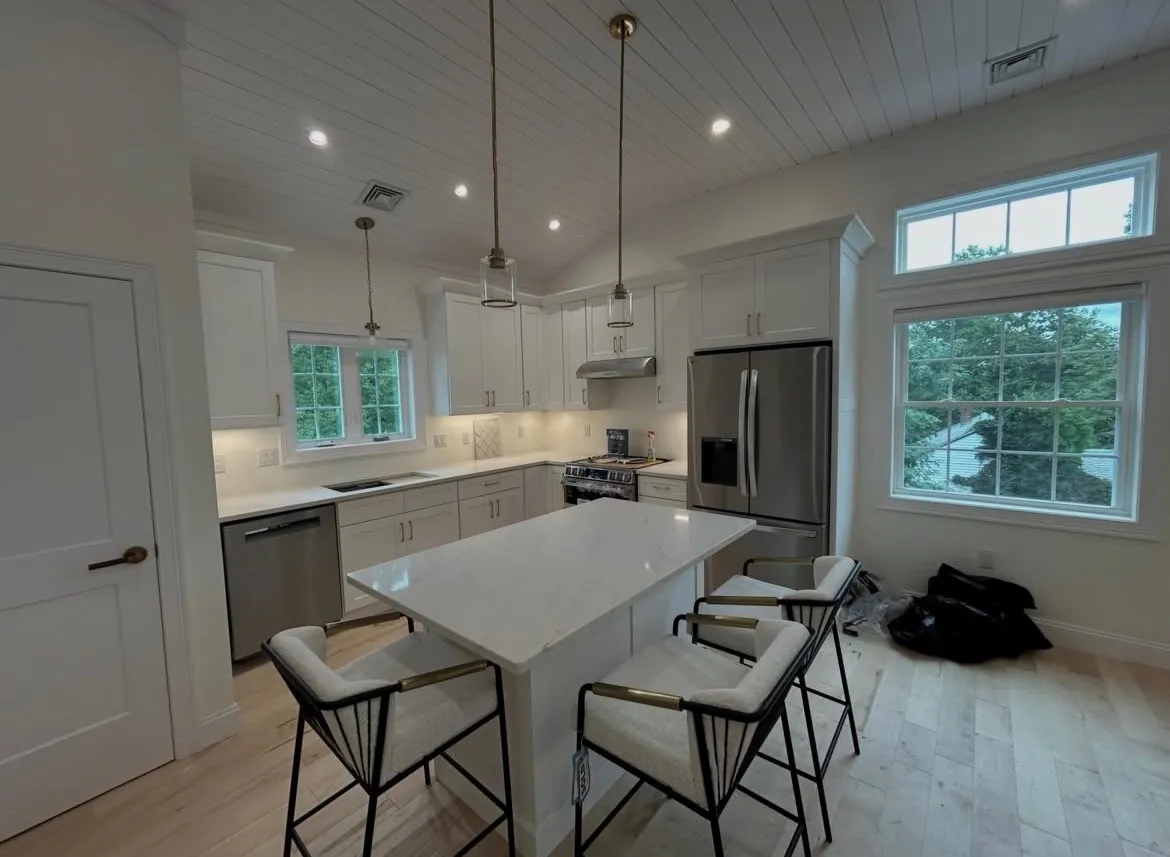 Pendant and recessed lighting over a white kitchen island