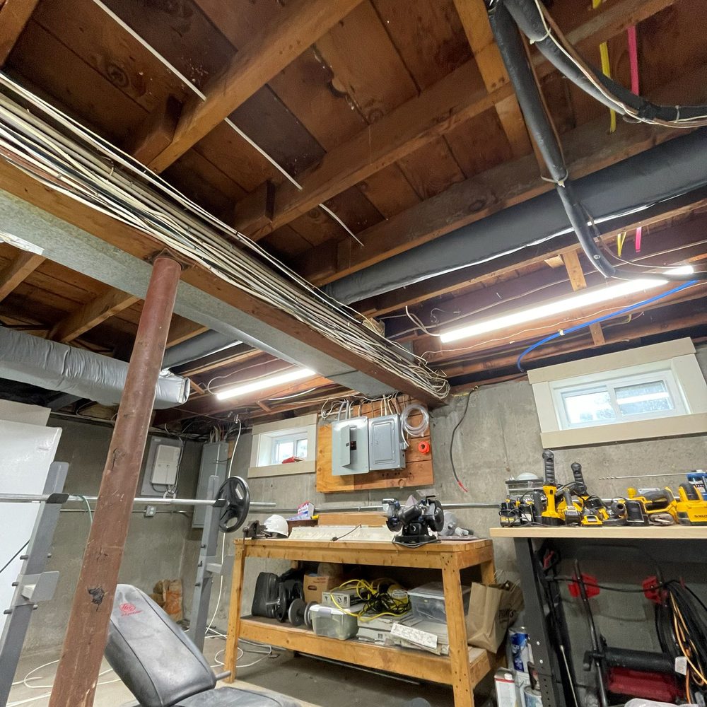 Boston Light & Power electrician running new basement lighting circuits in Weymouth, MA.