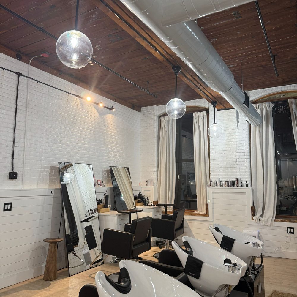 Boston Light & Power electrician installing pendant lighting in a salon in Quincy, MA.