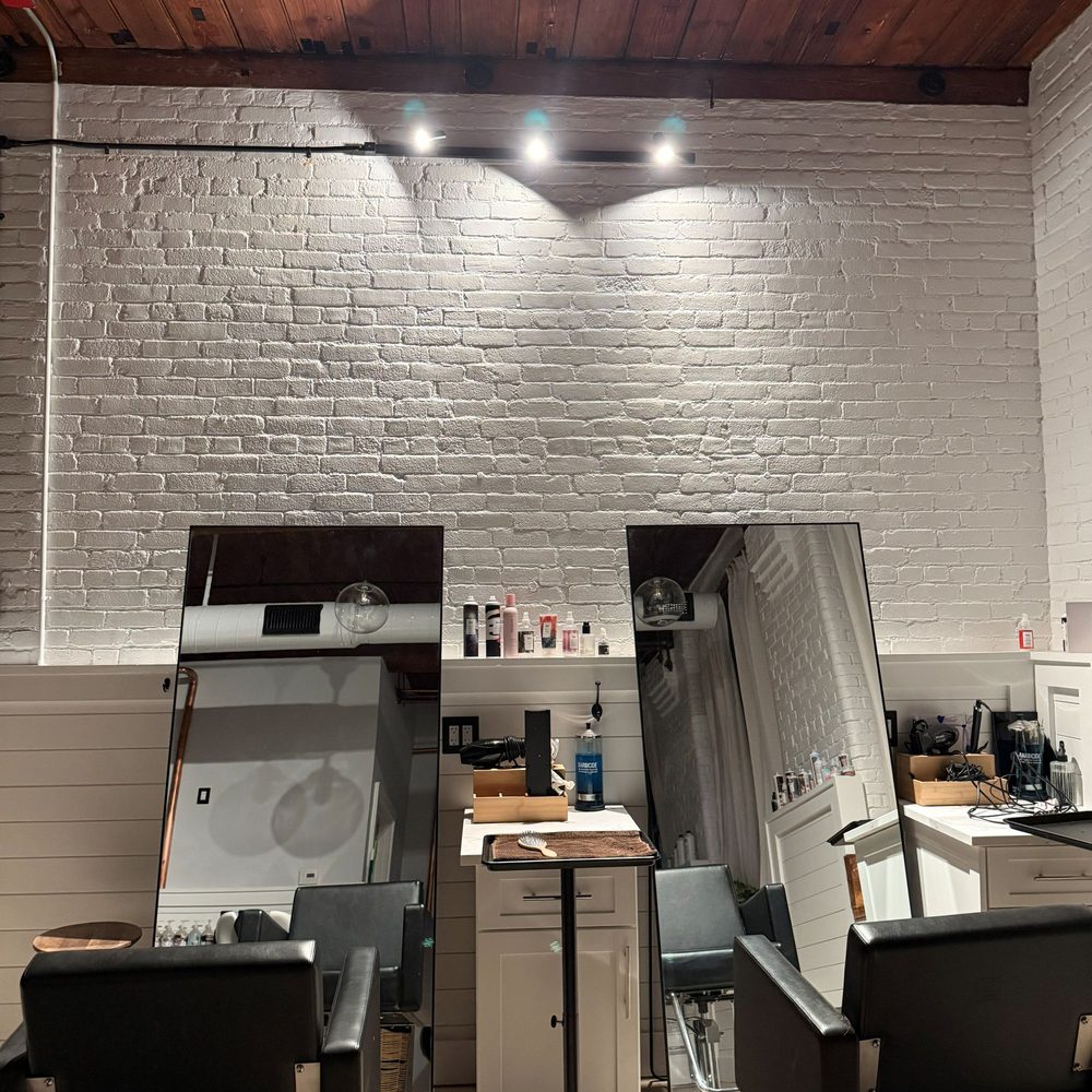 Boston Light & Power electrician installing track lighting in a salon in Quincy, MA.