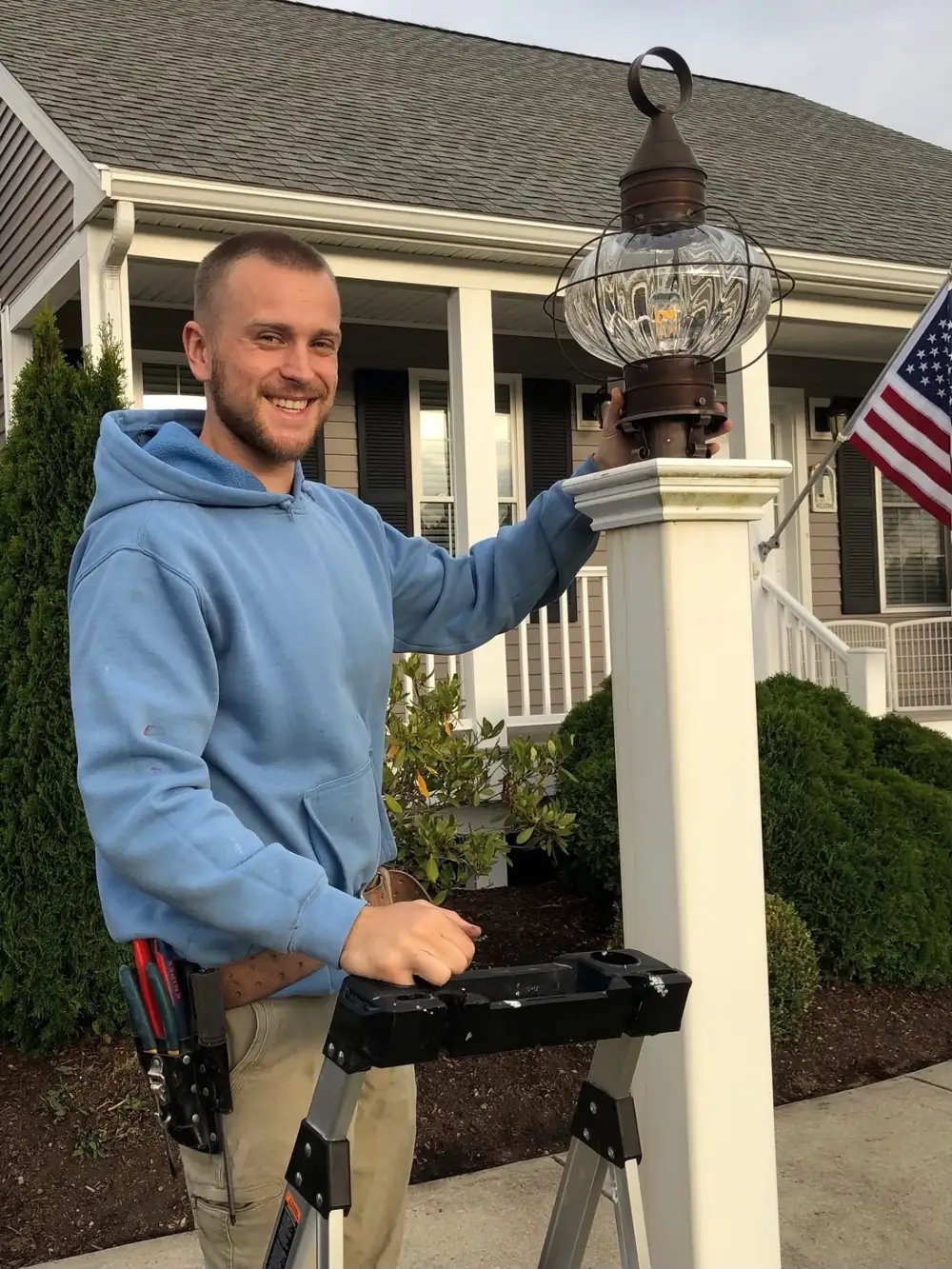 Boston Light & Power electrician installing an exterior post lantern